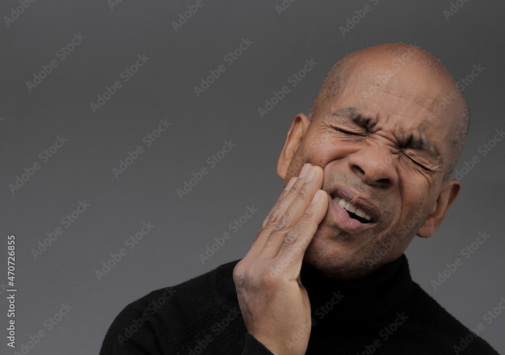 man with toothache in severe pain on grey background stock photo man with toothache in severe pain on grey background stock photo