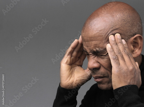 man with headache and migraine holding his head on grey background stock photo photo