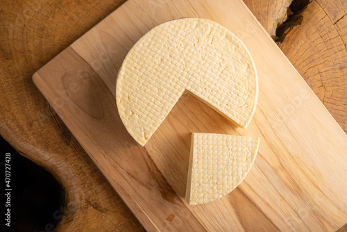 Fototapeta Naklejka Na Ścianę i Meble -  Semi-cured cheese from Brazil, beautiful Brazilian cheese arranged on light rustic wood, selective focus.