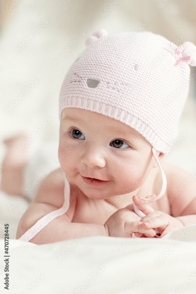 newborn baby girl in pink knitted hat on a bed newborn baby girl in pink knitted hat on a bed
