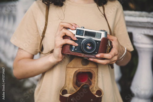 woman holding vintage camera in street