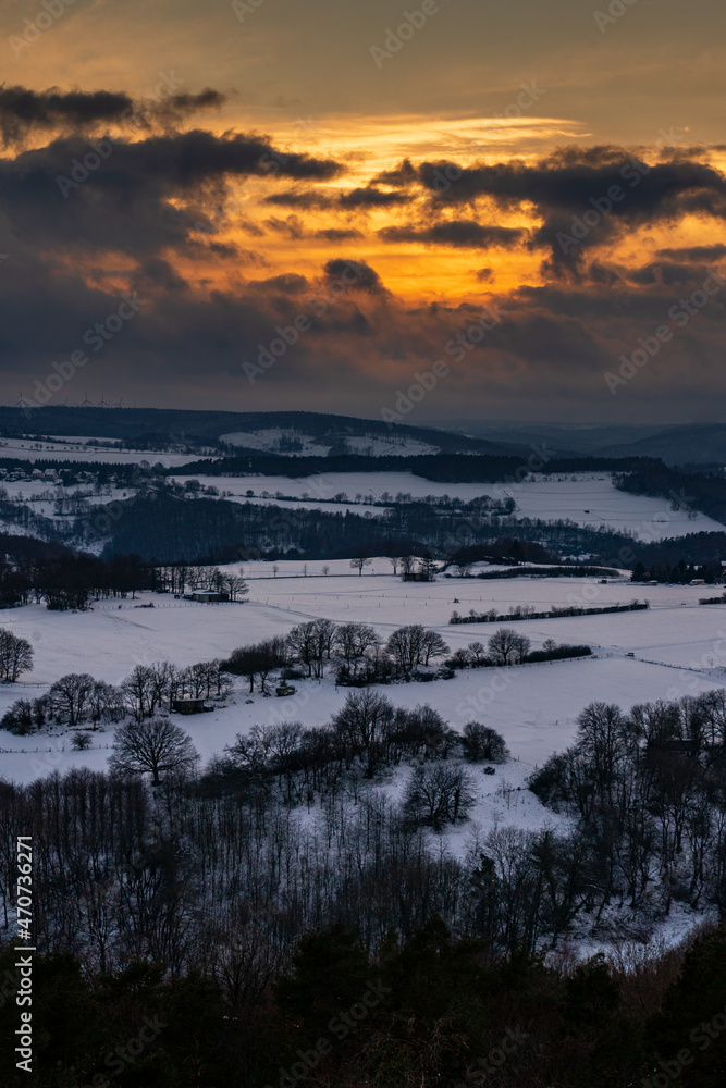 Dramatic sunset in the snow covered landscape on Nideggen, Eifel, Germany