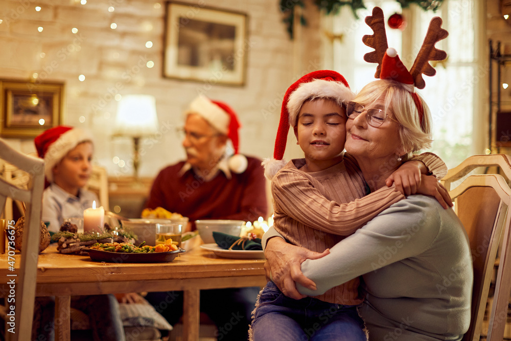 Senior woman and her granddaughter embracing with eyes closed on Christmas. Senior woman and her granddaughter embracing with eyes closed on Christmas.