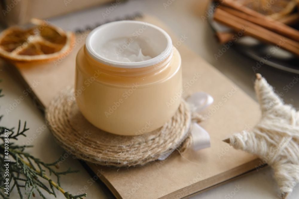 winter skin care cosmetic products with pine cones. Opened face cream jar winter skin care cosmetic products with pine cones. Opened face cream jar