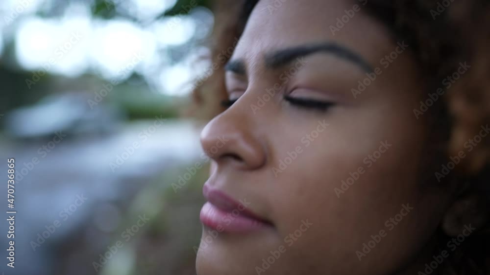 Brazilian person closing eyes taking a deep breath feeling free emotion fresh air Brazilian person closing eyes taking a deep breath feeling free emotion fresh air