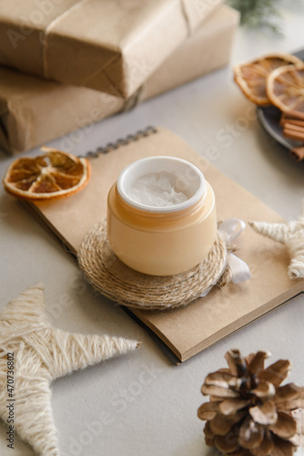  winter skin care cosmetic products with pine cones.  Opened face cream jar 