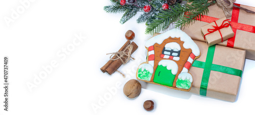 Christmas background with gifts and house cookies. Nuts with vanilla and cinnamon, a branch on the background.