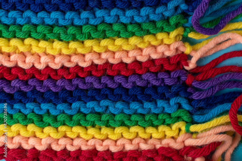 hand knitting background featuring rainbow coloured super chunky yarn 