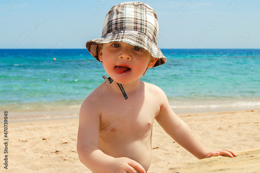 A small child runs along the beach of the Red Sea and makes faces. Safaga Coast, Egypt. A small child runs along the beach of the Red Sea and makes faces. Safaga Coast, Egypt.