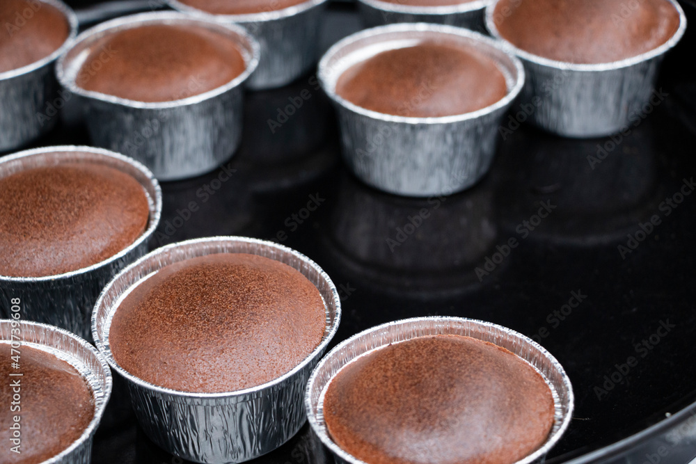 Freshly baked chocolate souffles dusted with powdered sugar. French traditional delicious chocolate souffle on baking tray. Freshly baked chocolate souffles dusted with powdered sugar. French traditional delicious chocolate souffle on baking tray.