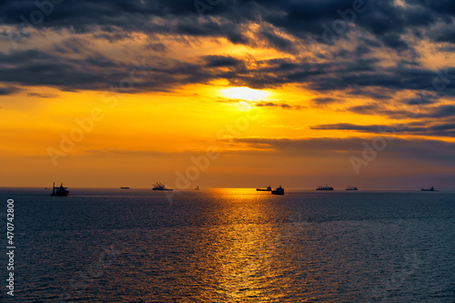 Beautiful sunset in the sea and ships. The sun shines through the clouds and is reflected in the waves © soleg