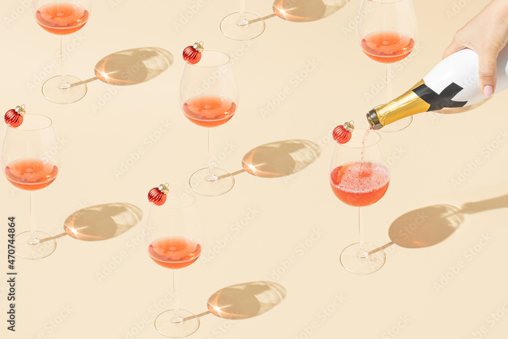 Creative pattern made with wine glass and bottle and Christmas baubles. Minimal beige New Year party background. Creative pattern made with wine glass and bottle and Christmas baubles. Minimal beige New Year party background.