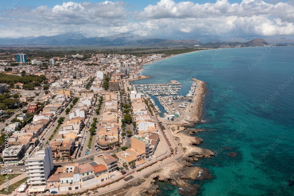 Aerial drone photo of the beach front on the Spanish island of Majorca Mallorca, Spain viewed from above on a bright sunny summers day showing the beach front in the village of Can Picafort