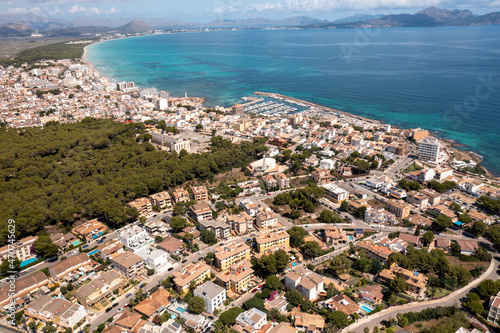 Aerial drone photo of the beach front on the Spanish island of Majorca Mallorca, Spain viewed from above on a bright sunny summers day showing the beach front in the village of Can Picafort