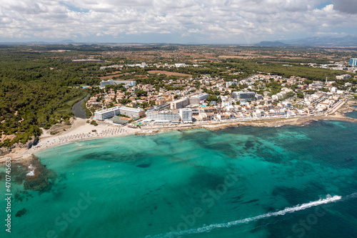 Aerial drone photo of the beach front on the Spanish island of Majorca Mallorca, Spain viewed from above on a bright sunny summers day showing the beach front in the village of Can Picafort