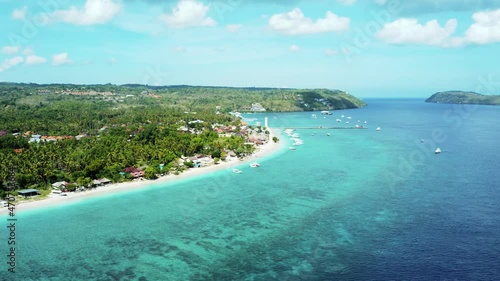 Fly along white sand beach small tropical island Nusa Pendida Bali Indonesia. High quality aerial 4k footage