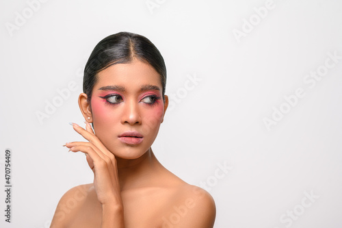The woman put on pink makeup and put her hand on her face.