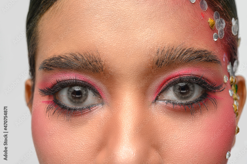 Obraz premium Woman wearing pink makeup and embellishments on her face