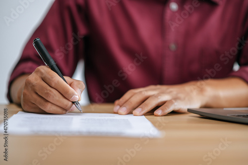 Male employee signing documents to approve work