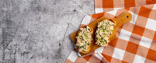 Tuna Salad open faced Sandwiches on a small cutting wooden board on a dark grey background. Top view, flat lay