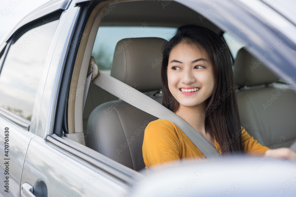 Young beautiful asian women getting new car. she very happy and excited looking outside window. Smiling female driving vehicle on the road on a bright day Young beautiful asian women getting new car. she very happy and excited looking outside window. Smiling female driving vehicle on the road on a bright day