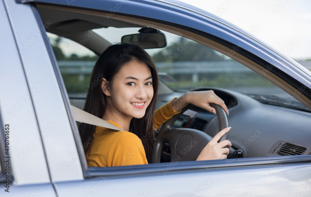Young beautiful asian women getting new car. she very happy and excited. she sit and touching every detail of car. Smiling female driving vehicle on the road