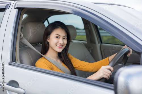 Young beautiful asian women getting new car. she very happy and excited. she sit and touching every detail of car. Smiling female driving vehicle on the road