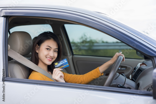Young beautiful asian women getting new car. Hand holding credit card payment. Car owner paying fuel pump with credit card customer mileage point loyalty reward