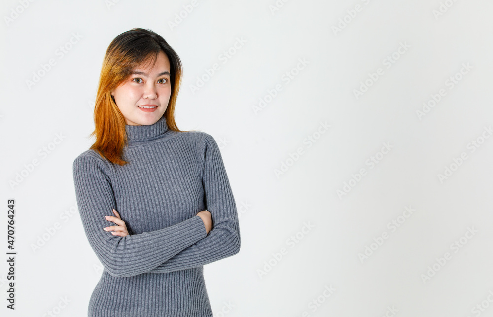 Portrait studio shot of Asian young urban trendy happy confident female successful businesswoman model in long sleeve turtleneck sweater standing look at camera crossed arms on white background Portrait studio shot of Asian young urban trendy happy confident female successful businesswoman model in long sleeve turtleneck sweater standing look at camera crossed arms on white background