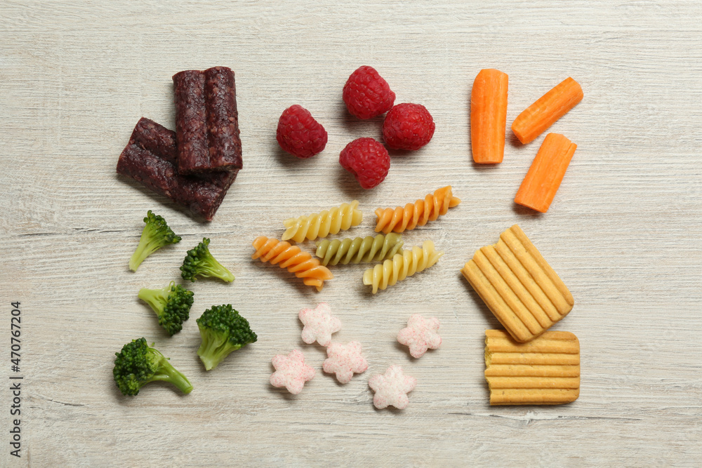 Set of different finger foods for baby on beige wooden table, flat lay Set of different finger foods for baby on beige wooden table, flat lay