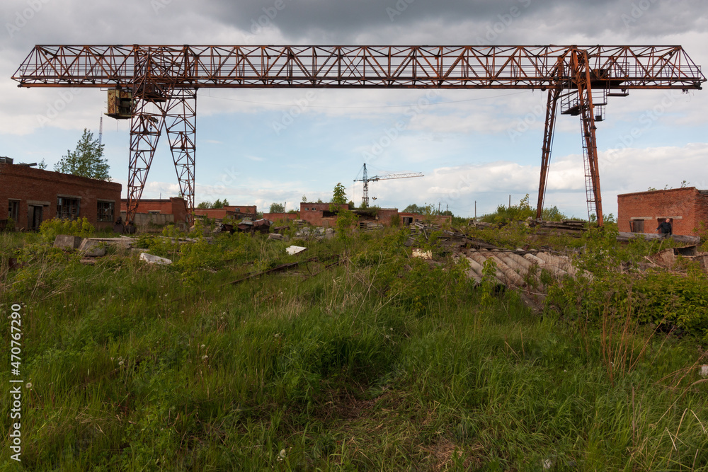 an abandoned gantry loading crane in a grassy area