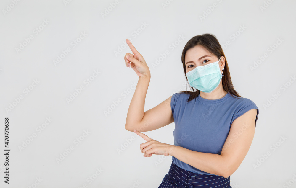Beautiful Asian woman wearing hygiene facemask pointing fingers to interesting health care and important medical message to protect coronavirus infection Beautiful Asian woman wearing hygiene facemask pointing fingers to interesting health care and important medical message to protect coronavirus infection