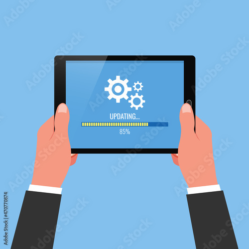 Hand holding tablet with system being updated symbol.