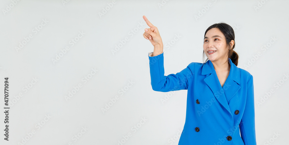 Lovely Asian lady on beautiful blue jacket smiling with happy and pointing finger to guide interesting direction and amazing message Lovely Asian lady on beautiful blue jacket smiling with happy and pointing finger to guide interesting direction and amazing message