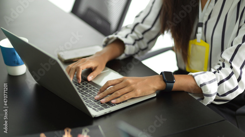 Employee on a laptop computer replying to client emails.