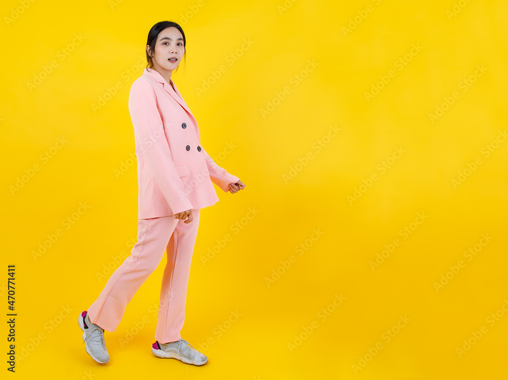 Attractive and cute Asian girl on beautiful pink business jacket, pants, and sneakers easily walking and smile as pretty model for woman beauty, clothing, outfit fashion Attractive and cute Asian girl on beautiful pink business jacket, pants, and sneakers easily walking and smile as pretty model for woman beauty, clothing, outfit fashion
