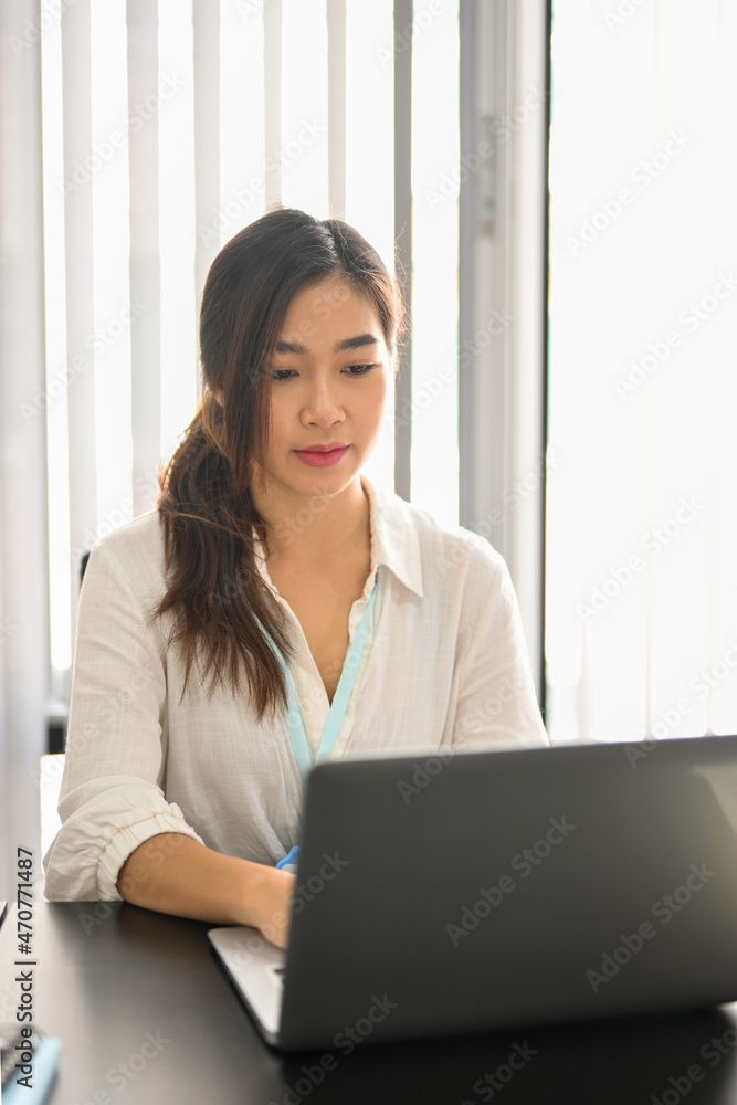 Business female employee focused on her project, working on laptop Business female employee focused on her project, working on laptop