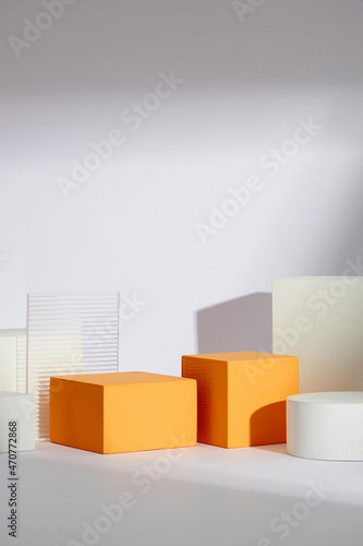 Front view of white and orange podium with and flower in a white background for advertising , abstract content