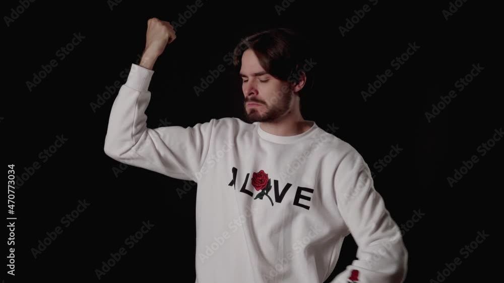Trendy Young Man flexing biceps, show off gesture, muscles, wide, black background Trendy Young Man flexing biceps, show off gesture, muscles, wide, black background