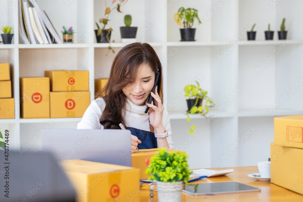Work from home. happy women selling products online Start a small business owner by using smartphone and laptop computer to calculate prices and prepare for postage. Work from home. happy women selling products online Start a small business owner by using smartphone and laptop computer to calculate prices and prepare for postage.