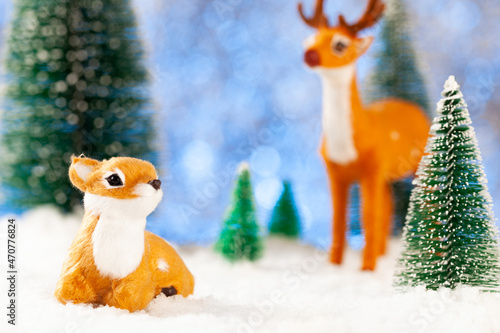 greeting new year card, two little toy deer in the snow
