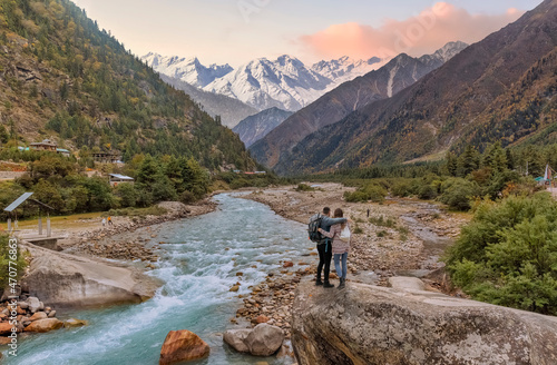 Tourist couple enjoy a vacation at the scenic Baspa river valley with view of Himalaya mountain range at Rakchham, Himachal Pradesh, India © Roop Dey