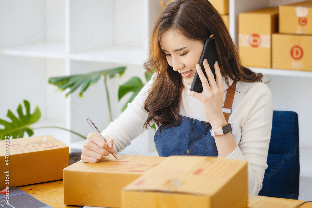 Work from home. happy women selling products online Start a small business owner by using smartphone and laptop computer to calculate prices and prepare for postage. Work from home. happy women selling products online Start a small business owner by using smartphone and laptop computer to calculate prices and prepare for postage.