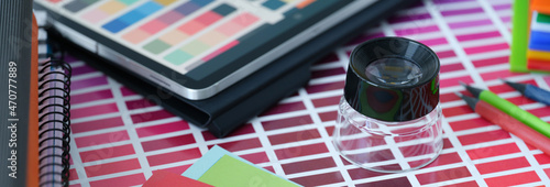 Color palette with colored paper and tablet with color samples lie on table photo