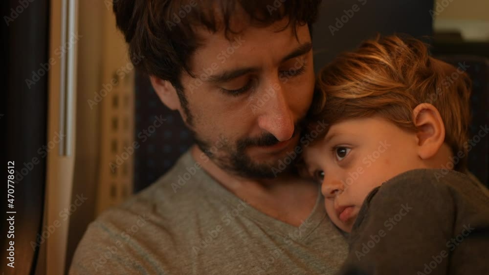 Father holding toddler while traveling by train Father holding toddler while traveling by train