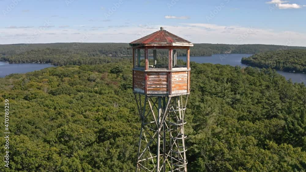 Drone reversing away from tall fire tower beside lakes in Ontario Canada, Drone reversing away from tall fire tower beside lakes in Ontario Canada,