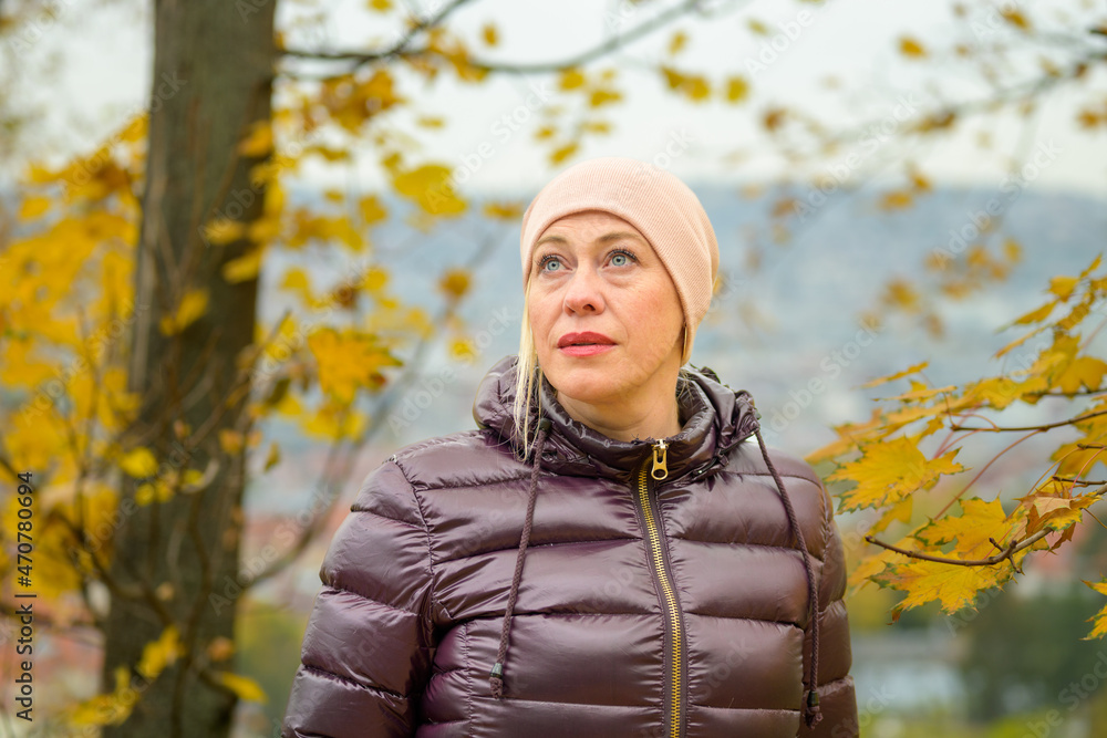 Thoughtful woman with a faraway expression outdoors in autumn Thoughtful woman with a faraway expression outdoors in autumn