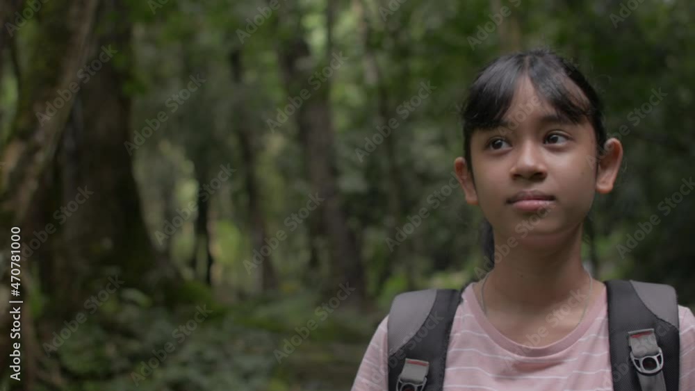 Asian pretty girl with backpack looking around while exploring in tropical rainforest at Phang Nga Province. Thailand jungle adventure. Hiking trip in the forest. Summer activities for young traveler. Asian pretty girl with backpack looking around while exploring in tropical rainforest at Phang Nga Province. Thailand jungle adventure. Hiking trip in the forest. Summer activities for young traveler.
