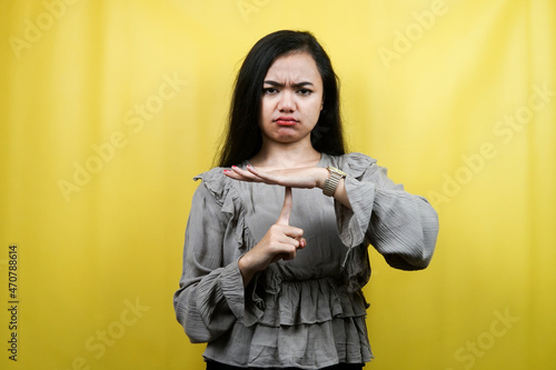 Beautiful young woman seriously, with hands stop talking, don't make noise, please be quiet, isolated