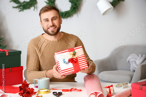 Smiling man holding wrapped...